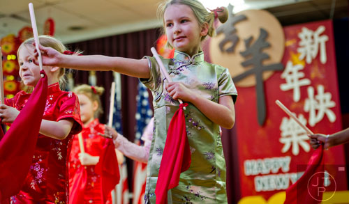Abby Slade (center) dances on stage with her classmates during the Chinese Lunar New Year celebration in Chamblee on Saturday, February 21, 2015. 