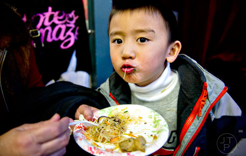 Easton Chen slurps up a noodle into his mouth during the Chinese Lunar New Year celebration in Chamblee on Saturday, February 21, 2015. 