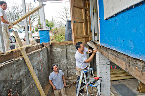 Jose Garcia (left) and his brothers Jamie and Julian work to rehab the space that used to be the front porch of the house at 880 Beryl St. in the Pittsburgh community of Atlanta on Wednesday, March 4, 2015. 