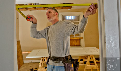 Ray Scarboro measures the space in between a doorway inside the house at 595 Rockwell St. in the Pittsburgh community of Atlanta on Wednesday, March 4, 2015. 