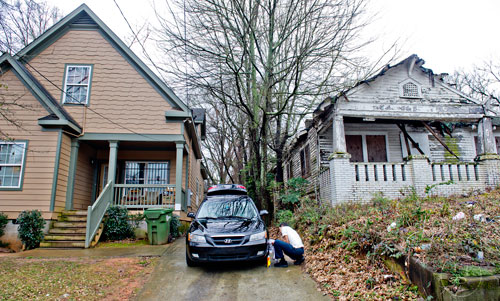 Solomon West washes his car at his home off of Rockwell St. in the Pittsburgh community of Atlanta that sits next door to a condemned property on Wednesday, March 4, 2015. 