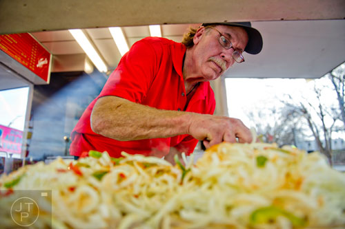 Mike Jeffers checks his peppers, onions and sausages on the grill at the Atlanta Fair on Wednesday, March 4, 2015. 