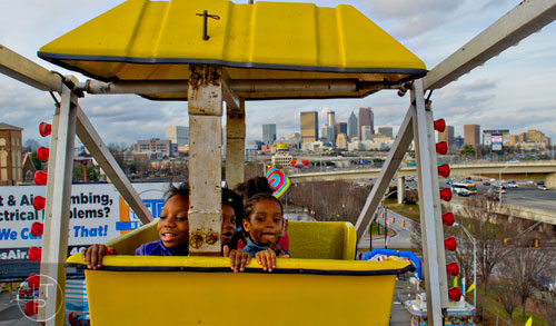 Bre Crawford (left), her sister Lucy and brother Brian ride the Expo Wheel as the sun sets over downtown at the Atlanta Fair on Wednesday, March 4, 2015. 