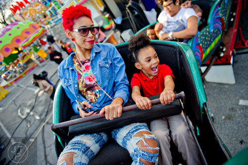 Ronesha Rolax (left) and her daughter Mariah hold onto the handlebar as they ride the Orient Express at the Atlanta Fair on Wednesday, March 4, 2015.