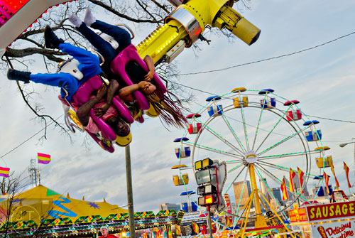 Christopher Watson (left) and Alisha Medley hang upside down as they ride Experience at the Atlanta Fair on Wednesday, March 4, 2015.