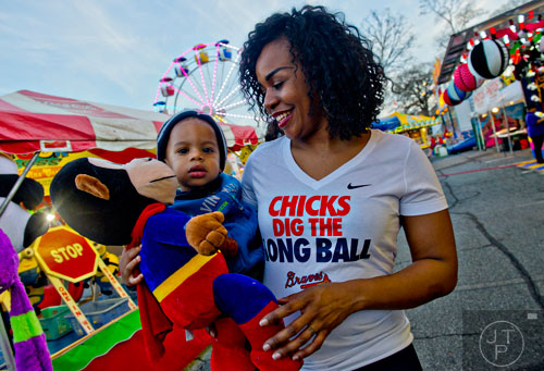 Jade Cobbins (right) holds her son Jordan while he holds a stuffed animal as they walk down the Midway at the Atlanta Fair on Wednesday, March 4, 2015.