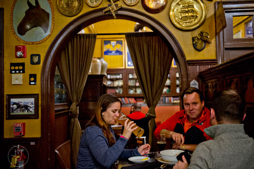 Cheri Mills (left) takes a sip of her beer as she talks with her husband Dylon and James Matthews at Mac McGee in Roswell on Friday, February 27, 2015. 