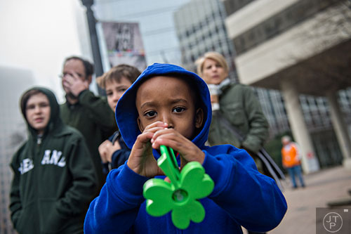 Ashton Keith (center) blows his trumpet as he waits for the start of the 2015 Atlanta St. Patrick's Parade on Saturday, March 14, 2015. 