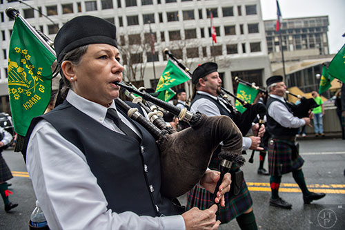 Janice Summers (left) plays the bagpipes as she marches down Peachtree St. during the 2015 Atlanta St. Patrick's Parade on Saturday, March 14, 2015.
