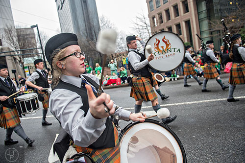 Alison Recknagel (center) twirls her drum sticks as she marches down Peachtree St. during the 2015 Atlanta St. Patrick's Parade on Saturday, March 14, 2015. 