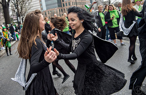 Sydnee Lewand (center) dances with Tricia McLeer down Peachtree St. during the 2015 Atlanta St. Patrick's Parade on Saturday, March 14, 2015. 