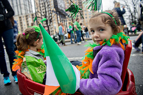 Emma Kelly (right) holds an Irish flag as she rides in a wagon down Peachtree St. during the 2015 Atlanta St. Patrick's Parade on Saturday, March 14, 2015. 