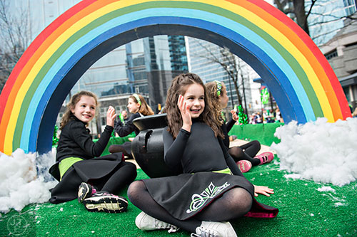 Mia Rosario (center) and Falyn Handley wave to the crowd as they ride a float down Peachtree St. during the 2015 Atlanta St. Patrick's Parade on Saturday, March 14, 2015.