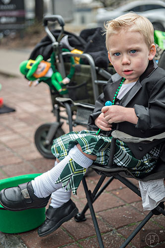 Wearing a kilt, two-year-old Michael Rumsey watches as the 2015 Atlanta St. Patrick's Parade makes its way down Peachtree St. on Saturday, March 14, 2015. 