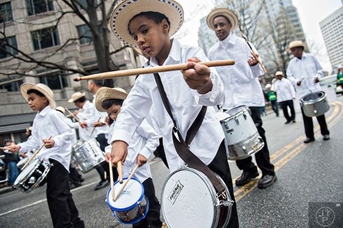 Kelvin Quiroh (center) beats on his drum as he marches down Peachtree St. during the 2015 Atlanta St. Patrick's Parade on Saturday, March 14, 2015. 