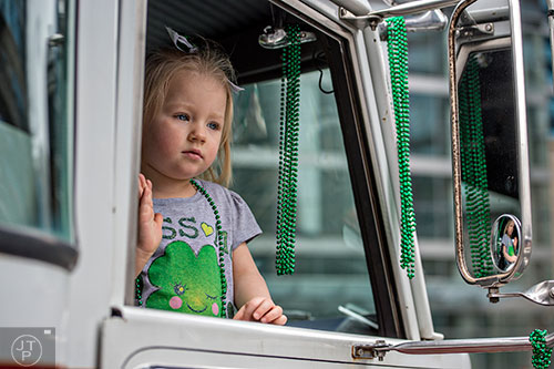 Addie Davis waves to the crowd from the window of a fire engine during the 2015 Atlanta St. Patrick's Parade on Saturday, March 14, 2015. 