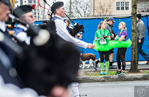 Anne Hewitt (right) talks with Erin Effner as they watch the 2015 Atlanta St. Patrick's Parade pass down Peachtree St. on Saturday, March 14, 2015. 