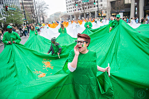 Megan DeSilva (center) screams as she helps carry the world's largest Irish flag down Peachtree St. during the 2015 Atlanta St. Patrick's Parade on Saturday, March 14, 2015. 
