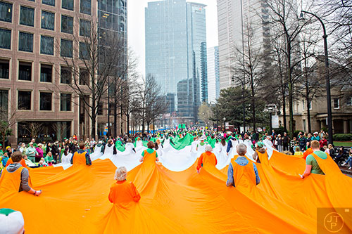 Volunteers carry the world's largest Irish flag down Peachtree St. during the 2015 Atlanta St. Patrick's Parade on Saturday, March 14, 2015. 