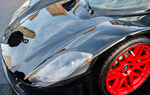 Antonio Alfieri (left) is reflected in the hood of one of the numerous Italian sports cars that were present during the Caffeine & Exotics Car Show at Lenox Square Mall in Atlanta on Sunday, March 15, 2015. 