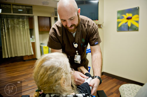 Joey Muller (center) takes a patient's vital signs before she undergoes medication at the Cancer Treatment Centers of America's Southeastern Regional Medical Center in Newnan on Friday, February 20, 2015. 