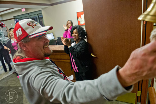 Jameka Bailey (right) and Jennifer Huff clap for Ron Butler (center) as he rings a bell during his graduation ceremony signifying the end of his radiation treatment at the Cancer Treatment Centers of America's Southeastern Regional Medical Center in Newnan on Friday, February 20, 2015.  
