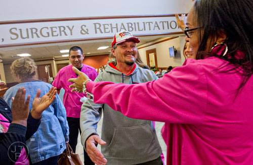 Ron Butler (center) is hugged by Jennifer Huff after receiving his final radiation treatment at the Cancer Treatment Centers of America's Southeastern Regional Medical Center in Newnan on Friday, February 20, 2015. 