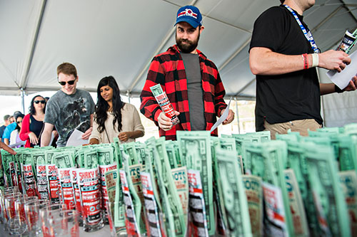 Mark Hubbard (center) picks up his sampling glass as he enters the sixth annual Beer Carnival at Atlantic Station in downtown Atlanta on Saturday, March 21, 2015.