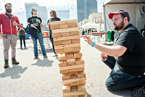 Joshua Doherty (right) gives up on his game of Jenga as Cody Wilson, Ian Wilmot and Morgan Shealy watch him tip over the tower of blocks during the sixth annual Beer Carnival at Atlantic Station in downtown Atlanta on Saturday, March 21, 2015.