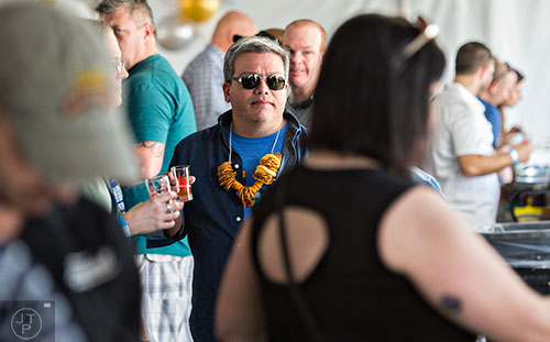 Marc Nevarez (center) stands in line for a sample of beer during the sixth annual Beer Carnival at Atlantic Station in downtown Atlanta on Saturday, March 21, 2015. 
