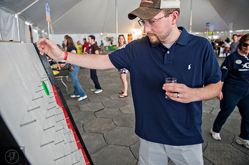 Brad House plays a game of Plinko during the sixth annual Beer Carnival at Atlantic Station in downtown Atlanta on Saturday, March 21, 2015. 