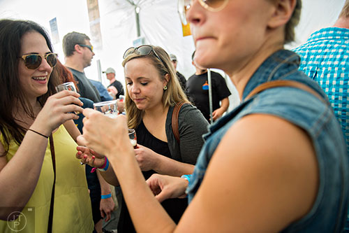 Marty Birch (left), Emylee Tanner and Cydney Davis taste different beers during the sixth annual Beer Carnival at Atlantic Station in downtown Atlanta on Saturday, March 21, 2015.