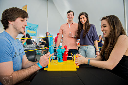 Fletcher Whitney (left) competes in a game of Rock 'Em Sock 'Em Robots against Elyse Vincenty (right) as Quinton Wirsing and Mary Fiorentino watch during the sixth annual Beer Carnival at Atlantic Station in downtown Atlanta on Saturday, March 21, 2015. 