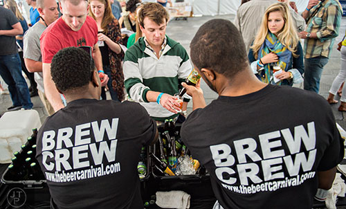 Adam Kemp (center) is handed a sample of beer during the sixth annual Beer Carnival at Atlantic Station in downtown Atlanta on Saturday, March 21, 2015. 