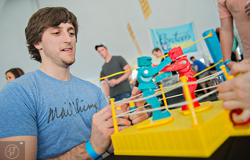 Fletcher Whitney (left) competes in a game of Rock 'Em Sock 'Em Robots during the sixth annual Beer Carnival at Atlantic Station in downtown Atlanta on Saturday, March 21, 2015.