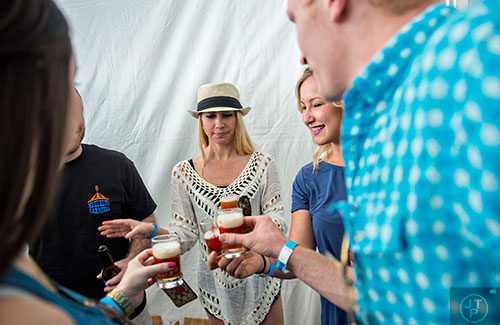 Danya Deegam (center), Shannon Steele, Tyler Davis and Anna Donovan cheers their tasting glasses during the sixth annual Beer Carnival at Atlantic Station in downtown Atlanta on Saturday, March 21, 2015. 