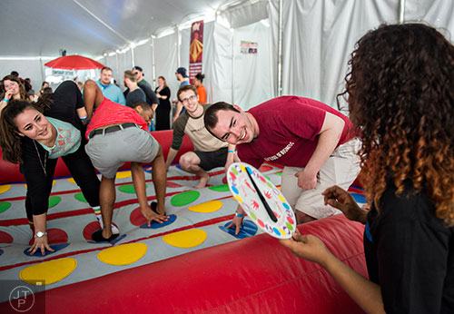 Rebecca Pollack (left), Rashad Small, Caleb Williams and David Brown reach for the correct color as Whitney Blue uses the spinner in a game of Twister during the sixth annual Beer Carnival at Atlantic Station in downtown Atlanta on Saturday, March 21, 2015.
