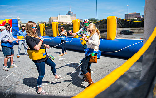 Hanna Ennis (right), Tyler Jones and Britain Baker play a human sized version of fusball during the sixth annual Beer Carnival at Atlantic Station in downtown Atlanta on Saturday, March 21, 2015. 