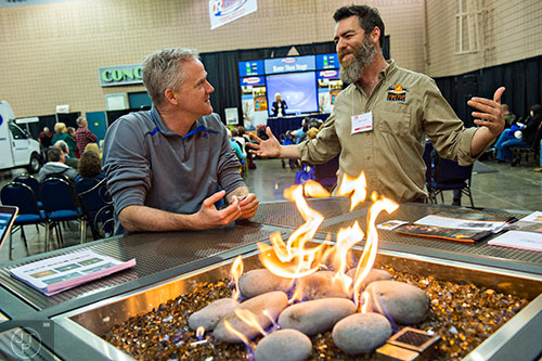 Mike Lipscomb (left) talks to Don Dudenhoeffer about firetop tables during the 37th annual Spring Atlanta Home Show at the Cobb Galleria Centre in Atlanta on Sunday, March 22, 2015.