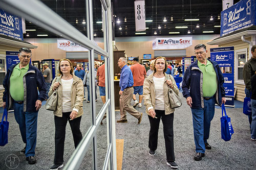 Peggy Gough (center) and her husband Gene walk past a mirrored garage door diplay during the 37th annual Spring Atlanta Home Show at the Cobb Galleria Centre in Atlanta on Sunday, March 22, 2015. 
