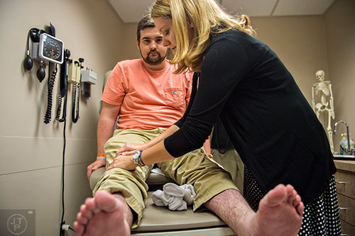 Dr. Heather Gladue (right) checks Drew Crenshaw's pain levels in his legs during his check up at the Emory Clinic off of Clifton Rd. in Atlanta on Friday, March 13, 2015. 