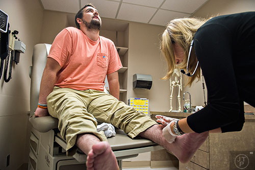 Drew Crenshaw looks towards the ceiling as Dr. Heather Gladue injects him with medication during his check up at the Emory Clinic off of Clifton Rd. in Atlanta on Friday, March 13, 2015. 
