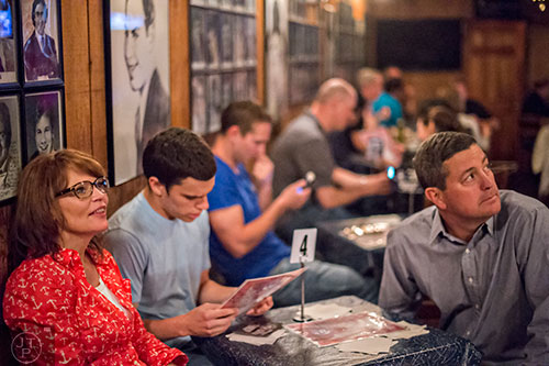 Jennifer Gastley (left) and her husband Dan look at pictures of comedians on the walls while their son Daniel looks at the menu as they wait for Billy Gardell to take the stage at The Punchline in Atlanta on Friday, March 20, 2015. 