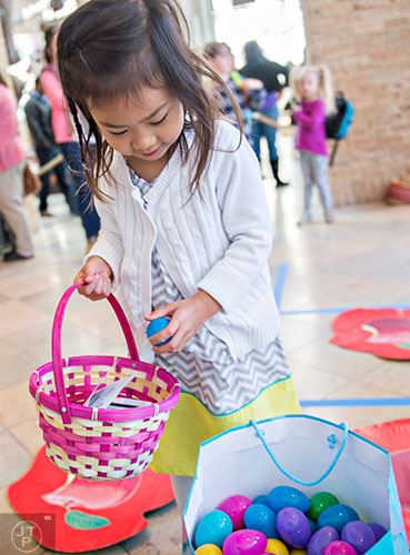 Isabella Ying places an Easter egg in her basket after competing in a game of tic-tac-toe during the Spring Egg-stravaganza event at the Fernbank Museum of Natural History in Atlanta on Saturday, March 28, 2015. 