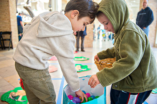Kaya Degertekin (left) and Connor Geoghan both reach for an Easter egg after competing in a game of tic-tac-toe during the Spring Egg-stravaganza event at the Fernbank Museum of Natural History in Atlanta on Saturday, March 28, 2015. 
