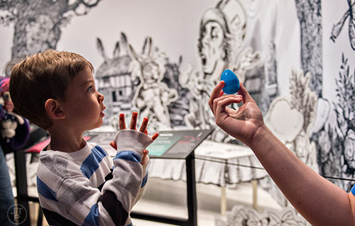 Christopher Collier is handed an egg inside The Power of Poison exhibit during the Spring Egg-stravaganza event at the Fernbank Museum of Natural History in Atlanta on Saturday, March 28, 2015. 