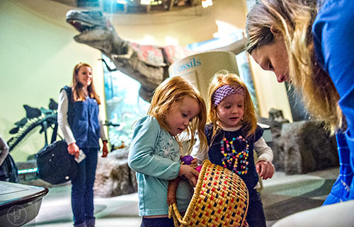 Carolyn Terry (center left) and her sister Eva are given Easter eggs by Elizabeth Finsthwait (right) during the Spring Egg-stravaganza event at the Fernbank Museum of Natural History in Atlanta on Saturday, March 28, 2015. 