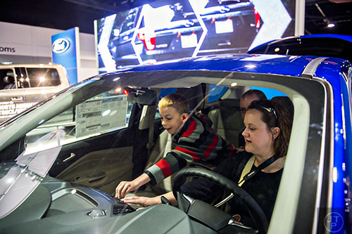 Stephanie Bryan (right), her husband Johnathan and son Gavin check out the interior of a Ford Escape during the Atlanta International Auto Show at the Georgia World Congress Center on Sunday, March 29, 2015.