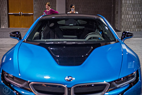 Shaina Guines (right) and Sherri Wylie take photos of the new BMW i8 during the Atlanta International Auto Show at the Georgia World Congress Center on Sunday, March 29, 2015. 
