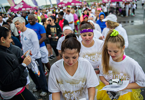 Catherine Baldo (center), Chiara Norce and Lizzie Baldo pick up their race packets before the start of The Color Run at Atlanta Motor Speedway in Hampton on Saturday, April 4, 2015. 